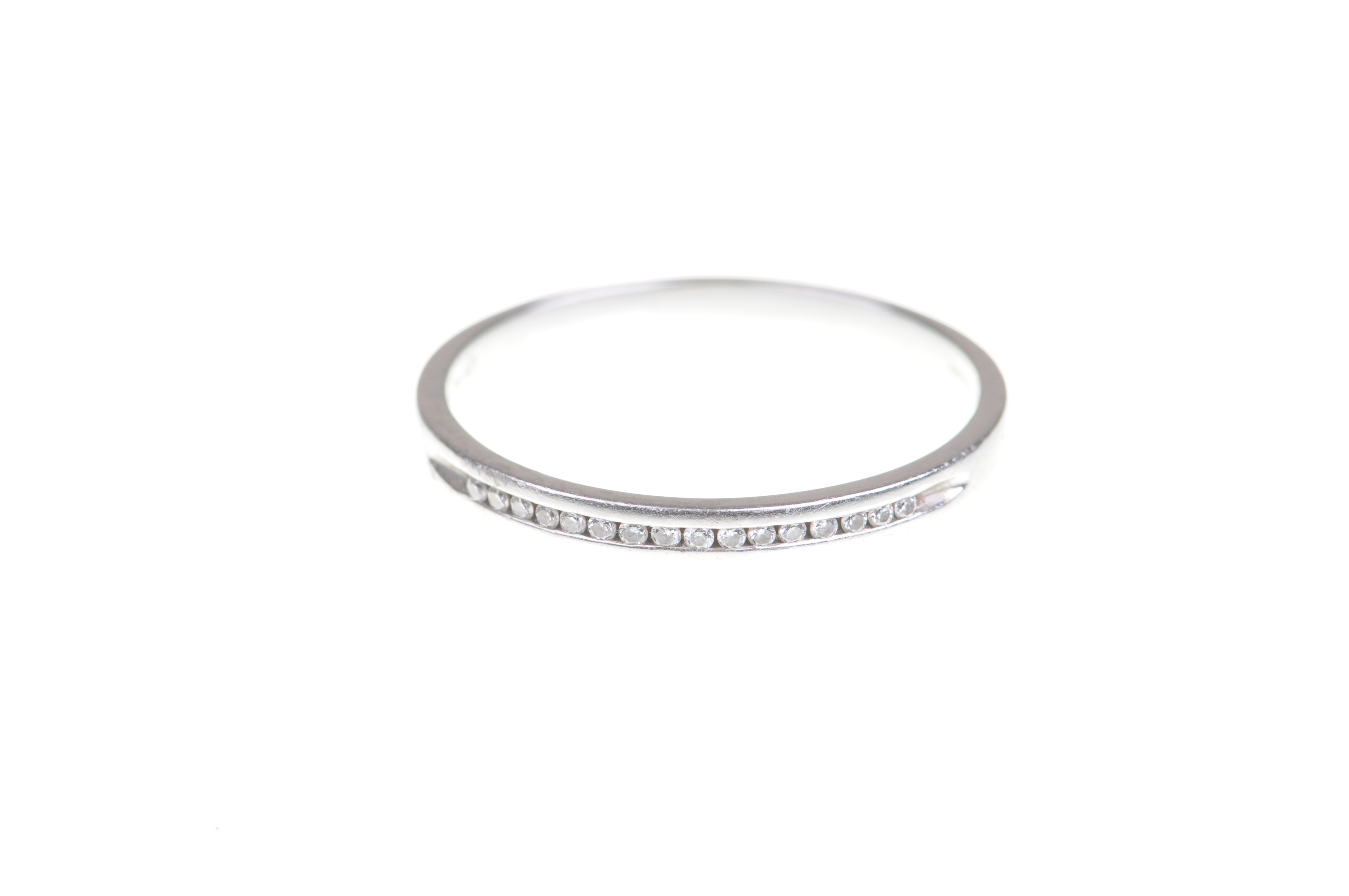 A diamond half hoop eternity ring With a uniform line of round brilliant-cut diamonds to a platinum