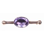 An early Victorian amethyst bar brooch The oval-shaped foil-backed amethyst, collet set,