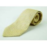 An Hermes silk tie The woven pale yellow ground, with blue speckled detail and spots of blue,