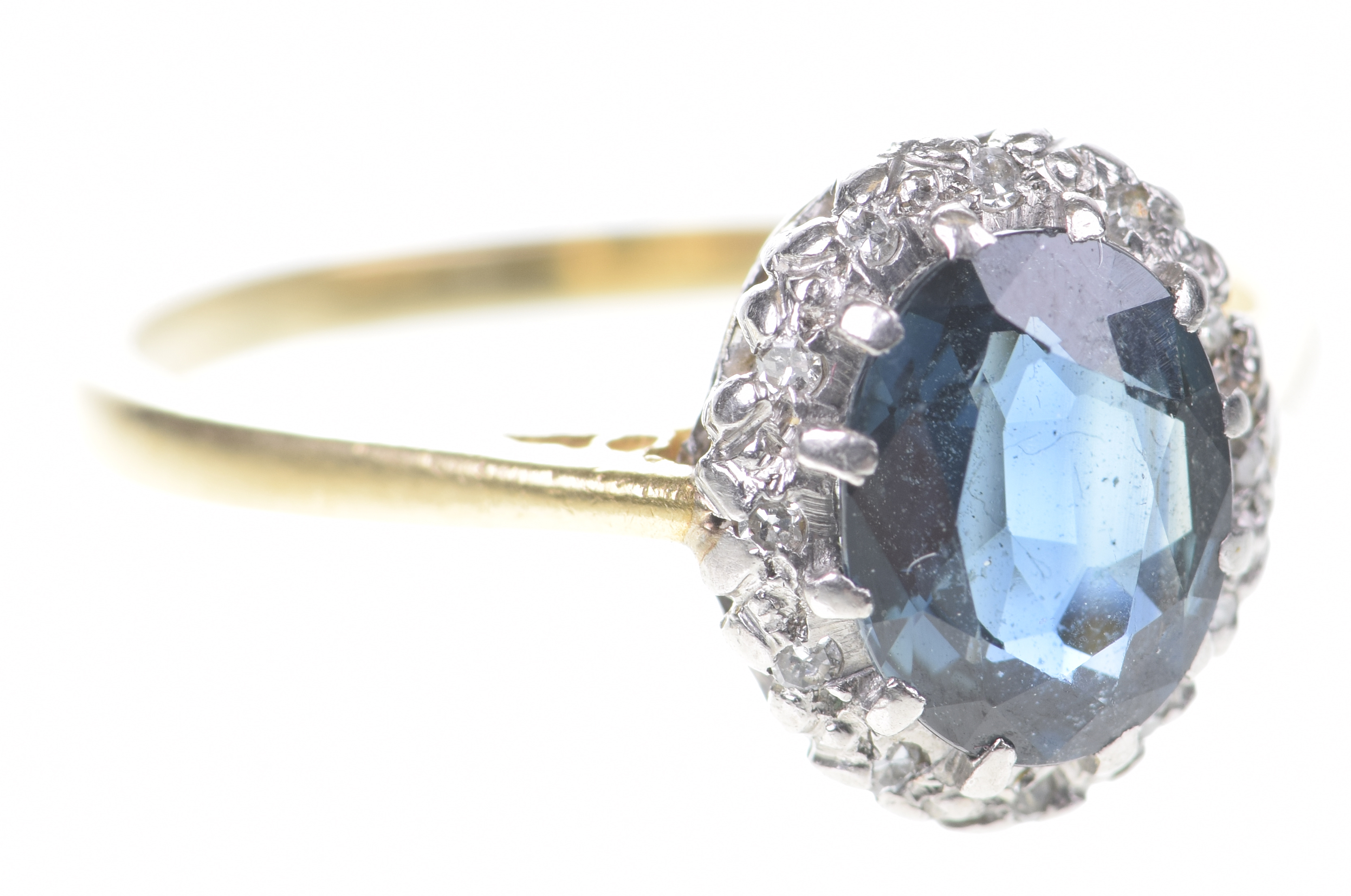 A sapphire and diamond cluster ring The oval-shaped sapphire, to a single-cut diamond surround,