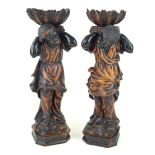 A pair carved wooden Blackamoor figures Circa 1900, each figure supporting open shells,