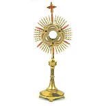 A decorative gilt brass church monstrance Modelled in the typical manner with central cross finial,