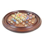 A large 19th Century solitaire board With thirty three onion skin marbles of various sizes,
