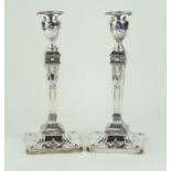 A pair of George V hallmarked silver candlesticks Each having repousse decoration depicting rams