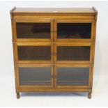An early 20th Century Minty of Oxford glazed oak bookcase of small proportions Having three pairs