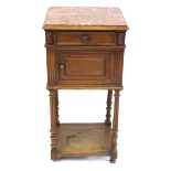 A French period style fruitwood bedside cabinet The marble top above panelled frieze drawer and