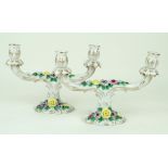 A pair of 20th Century Dresden floral encrusted twin handle candelabra Rising from a scalloped