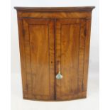 A George III inlaid and crossbanded mahogany bowfront hanging corner cupboard The moulded cornice