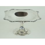 A George V hallmarked silver pedestal comport With cast rim having open shell corners,