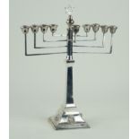 A George V hallmarked silver menorah With four relief lion mask heads to foot rim,