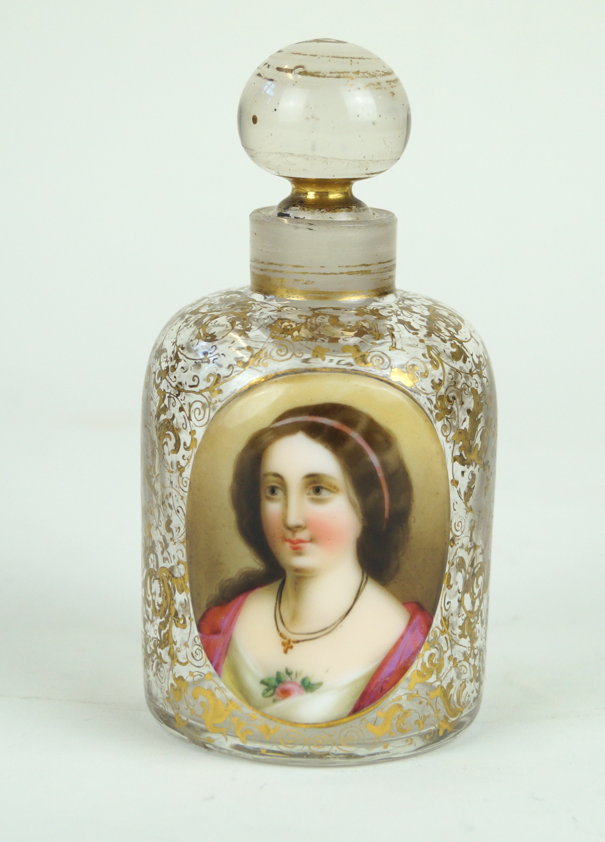 A 19th Century Bohemian perfume bottle and stopper The clear glass body having gilt scrolls with a