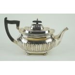 A George V hallmarked silver teapot Having planished decoration to lower body,