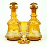 A pair of Bohemian amber glass decanters Each having engraved decoration of stags in landscape,