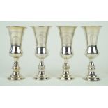 A harlequin set of four Edward VII hallmarked silver shot glasses Each having chased decoration,