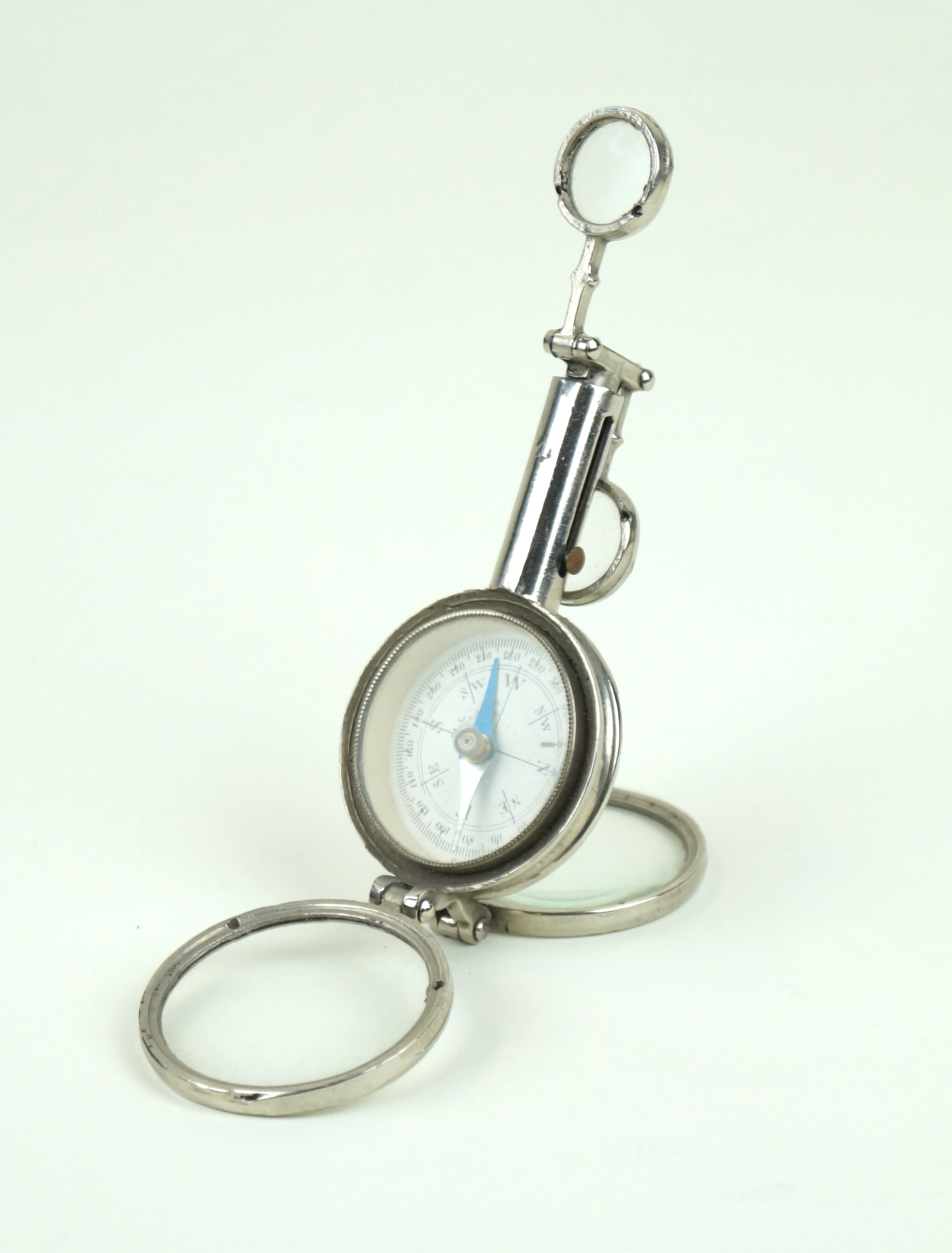 A French chromed miniature travelling compass With adjustable arm and two clear glass magnifiers,