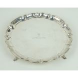 A George V hallmarked silver card tray With cast rim, raised on three hoof feet,