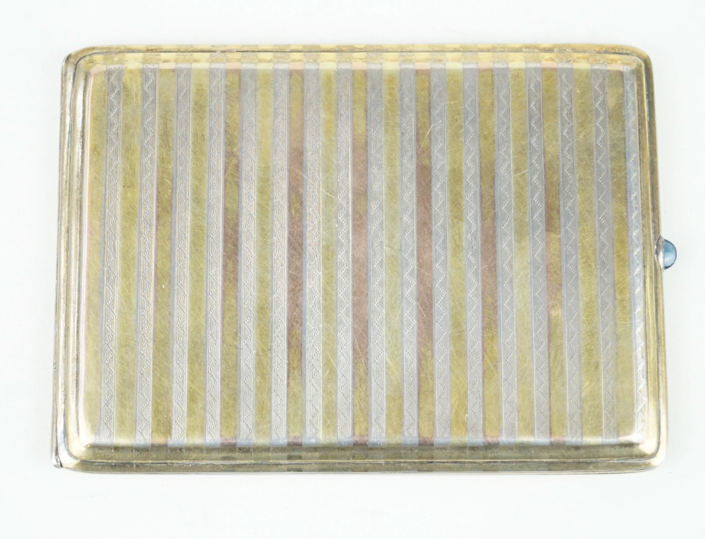 A sterling silver and silver-gilt cigarette case Having linear decoration inset between engraved