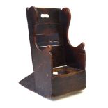 An 18th Century child's rocking commode chair The plain raised back incorporating carrying handle,