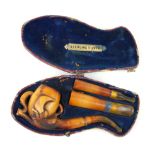 A cased three piece meerschaum smoking set Comprising claw pipe with amber coloured mouth piece,