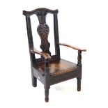 A Georgian carved oak child's open armchair Having a shaped top rail and foliate carved bars,