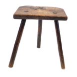 An 18th Century oak three legged stool The substantial top with canted rear edges,