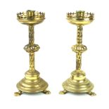 A pair of brass Gothic style candlesticks Early 20th Century,
