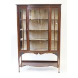 An Edwardian mahogany tall display cabinet Having a central bowed section,