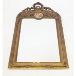 A Victorian gilt gesso wall mirror The domed rectangular form with ornate flower,