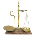 A set of Stevens & Co brass balance scales Raised on mahogany plinth base,