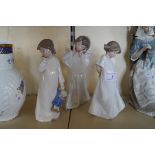 A Lladro figure of an angel together with two Nao figures of girls.