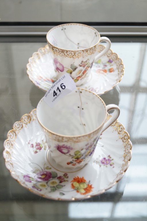 Two Dresden porcelain cups & saucers decorated with hand painted floral designs,