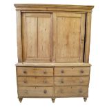 A Victorian stripped pine housekeeper's cupboard Featuring a moulded cornice above two sliding