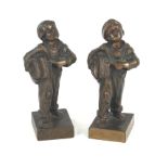 Two early to mid 20th Century cast bronze figures Each depicting paper boys, raised on plinth bases,