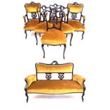An Edwardian seven piece salon suite The two seater sofa, pair of open sided armchairs,