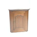 An 18th/19th Century oak hanging corner cupboard With a moulded dentil cornice above a single