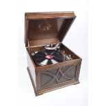 An oak cased "His Masters Voice" gramophone With a hinged caddy top above a front fretwork grille,