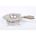 A continental white metal tea strainer and stand The tea strainer of circular form,