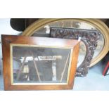 A carved oak framed oval bevelled wall mirror,