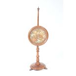 A mid 19th Century mahogany pole screen With a spherical finial and a circular glazed floral