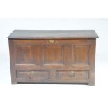 An 18th Century oak mule chest With a rectangular three plank moulded top above a frieze centred