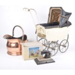 A child's doll pram, early 20th century The double seat pram with fold-down lid, metal wheels,