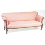 A Victorian walnut and upholstered settee The padded back above scroll terminal arms,