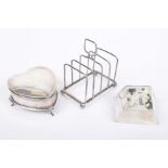 A silver dressing table box Of heart form, raised on three feet,