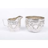 A Victorian silver sugar bowl and milk jug Of circular form, with an embossed fluted lower body,