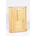 A Victorian pine hanging corner cupboard Having a single panelled cupboard door and brass knob