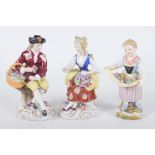 Three late 19th early 20th Century Continental figures To include a flower seller perched on a