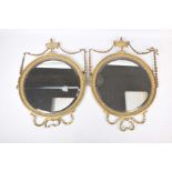 A pair of 19th Century gilt wood circular wall mirrors Each adorned with an urn and harebell swags