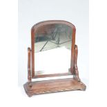 A 19th Century mahogany toilet mirror The arched plate supported on channelled curvilinear uprights,