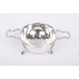 A modern silver tea strainer and stand Of circular form,