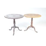 Two Georgian tripod tables The first with a scrolling foliate frieze and a rope edge raised on a